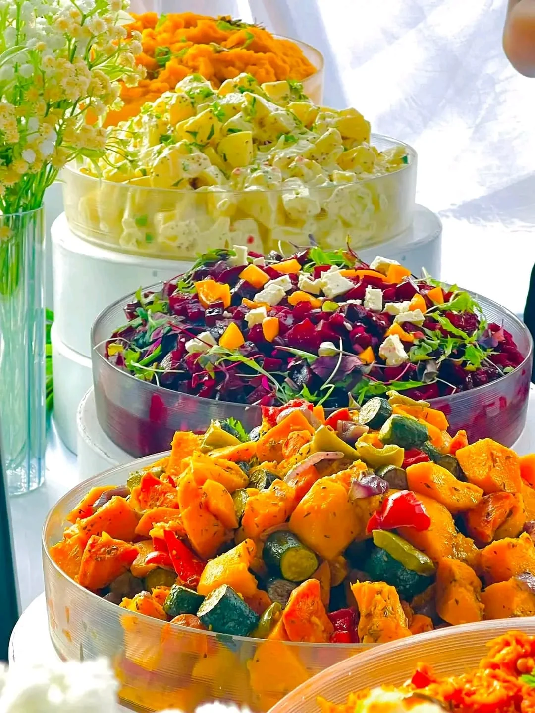 Fresh salad bowls arranged as part of a catering spread